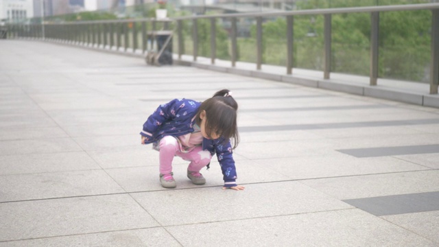 蹒跚学步的女孩走在上海的街道上