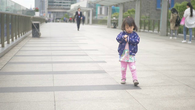 蹒跚学步的女孩走在上海的街道上