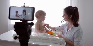 在线讲座，博主家庭医生用听诊器给宝宝检查小病人，并通过手机向粉丝直播学习
