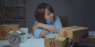一位年轻的亚洲女企业家，经营着一家中小企业，晚上在家办公，累得昏昏欲睡。小企业主在家办公的概念。