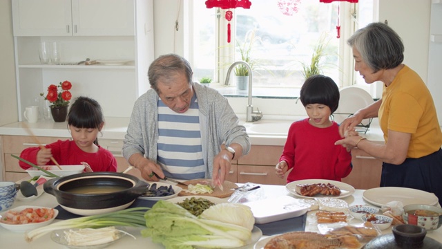 手持拍摄亚洲家庭烹饪厨房在新年