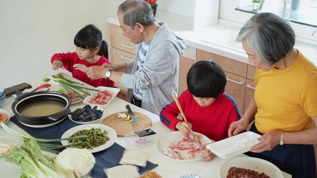 爷爷奶奶和孩子们在春节准备肉和菜吃火锅的慢镜头