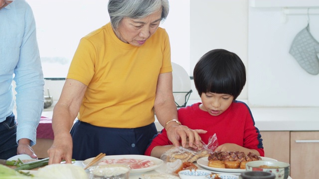 祖母和小男孩在厨房里拆食物包装