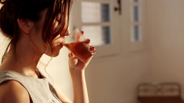一个年轻女子在家里喝茶的特写
