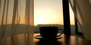 在日出的背景下，咖啡杯放在桌上
