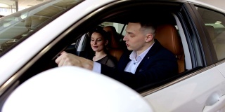 一对幸福的年轻夫妇在现代车展上买了一辆车。特写镜头。