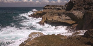 在阳光明媚的日子里，海水冲击着岩石