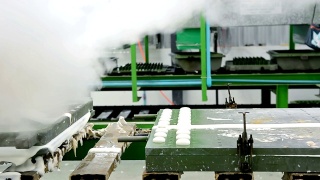 在橡胶枕厂的传送带上，用热蒸汽将金属乳胶枕模具从机器上移出视频素材模板下载