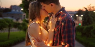 浪漫的约会男人拥抱女人亲吻仙女灯