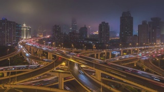 白天到夜晚的空中运动高架公路交汇处x形道路日落时的鸟瞰图时间流逝。交通运输概念在城市城市，上海市中心，中国在4k视频视频素材模板下载