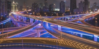 空中运动夜间时间高架公路交汇处x形道路夜间鸟瞰图的时间间隔。交通运输概念在城市城市，上海市中心，中国在4k视频
