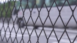 汽车在城市道路上通过栅栏网。在现代城市的高速公路上，通过钢丝网观察汽车和出租车的行驶情况视频素材模板下载