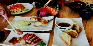 在日本料理餐厅用筷子吃日本料理和其他日本套餐的人。