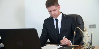 专业律师在律师事务所工作台上阅读、签署文件