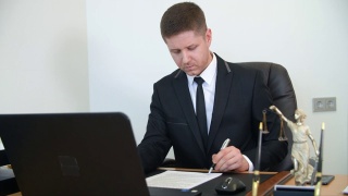 专业律师在律师事务所工作台上阅读、签署文件视频素材模板下载