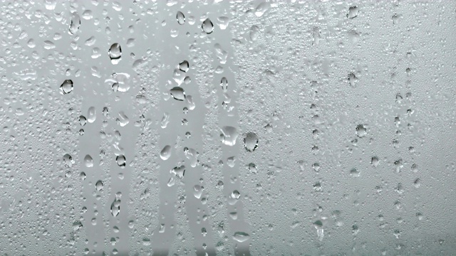在玻璃窗上关上一个带雨滴的蒸汽镜，以雨季为背景