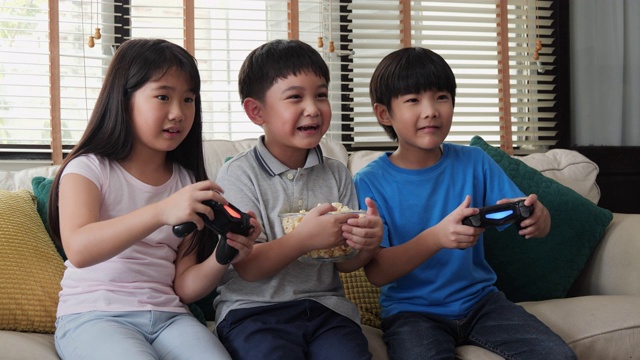 男孩和女孩在家里一起玩主机游戏。孩子们带着快乐的情绪玩游戏。