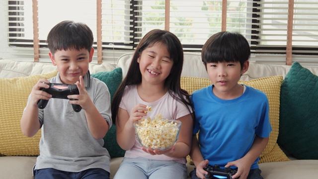 男孩和女孩在家里一起玩主机游戏。孩子们带着快乐的情绪玩游戏。