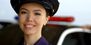 年轻迷人的女巡警对着镜头微笑，是专业警察