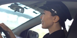 微笑的亚洲女警察调整司机座位上的帽子在巡逻车，职责