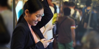 亚洲女性在火车上用智能手机使用社交媒体