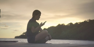 年轻女子在海边使用智能手机