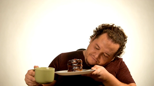 有趣的胖子在吃巧克力蛋糕。