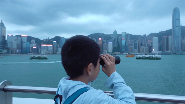 亚洲男孩用双筒望远镜环顾香港