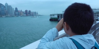 亚洲男孩用双筒望远镜看香港的建筑