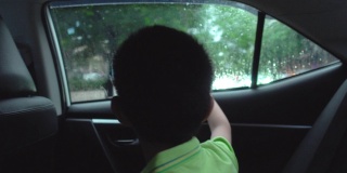 坐在车里看外面的亚洲男孩