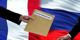 俄罗斯和法国官员交换机密信封，旗帜背景