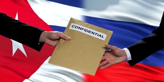 俄罗斯和古巴官员交换机密信封，旗帜背景