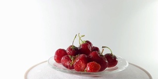 360度，在转盘上拍摄带叶子的红草莓。360°转弯。健康食品。美味的和维生素。节食和素食主义者。