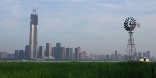 多叶片风力泵在中部汉口沼泽和武汉城市天际线的背景在中国湖北