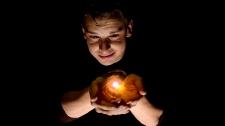一个男人拿着一个金色能量球的全息投影的未来场景。视频素材模板下载