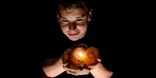 一个男人拿着一个金色能量球的全息投影的未来场景。