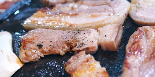 在韩国餐厅里煎煮黑猪肉饭，新鲜美味的韩国菜菜肴在铁板上配上生菜，拉近距离，复制空间，生活方式