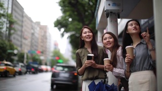 台湾女性朋友在雨中等公共汽车视频素材模板下载