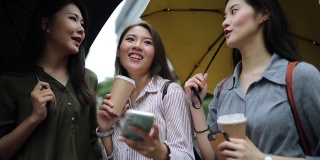 三个中国女性朋友在雨天心情好