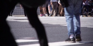 慢镜头人群在人行横道上行走。