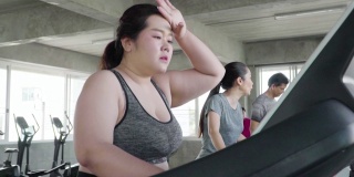 超重的年轻女子在跑步机上锻炼