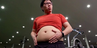 亚洲大体格男子在健身房展示他的肌肉。