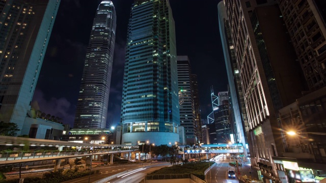 在香港现代建筑背景下，城市交通的灯光轨迹随着时间推移而变化