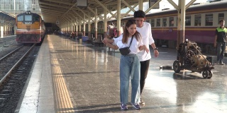 一对年轻的情侣在火车站跳舞
