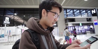 一名男子在机场用智能手机办理登机手续。