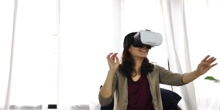 亚洲妇女在家里使用她的手机VR头盔。可负担得起的虚拟现实眼镜