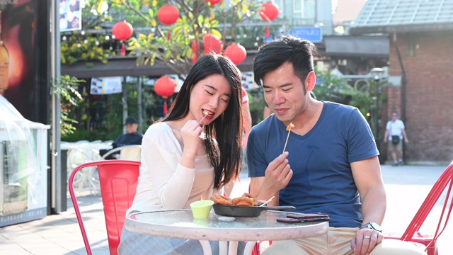 中国夫妇在咖啡馆吃零食聊天