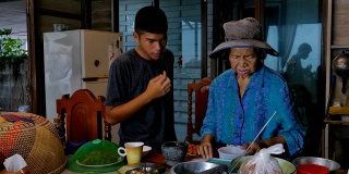 亚洲老年妇女和孙子在厨房做饭。
