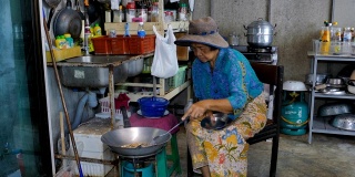 亚洲高级女性在厨房做饭。