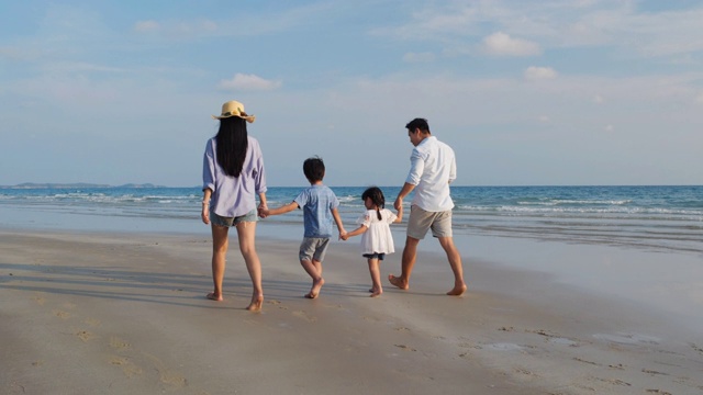 亚洲家庭愉快的散步，放松和休息在海滩夏季一起度假。家庭、旅游、暑期度假的概念。4 k决议。